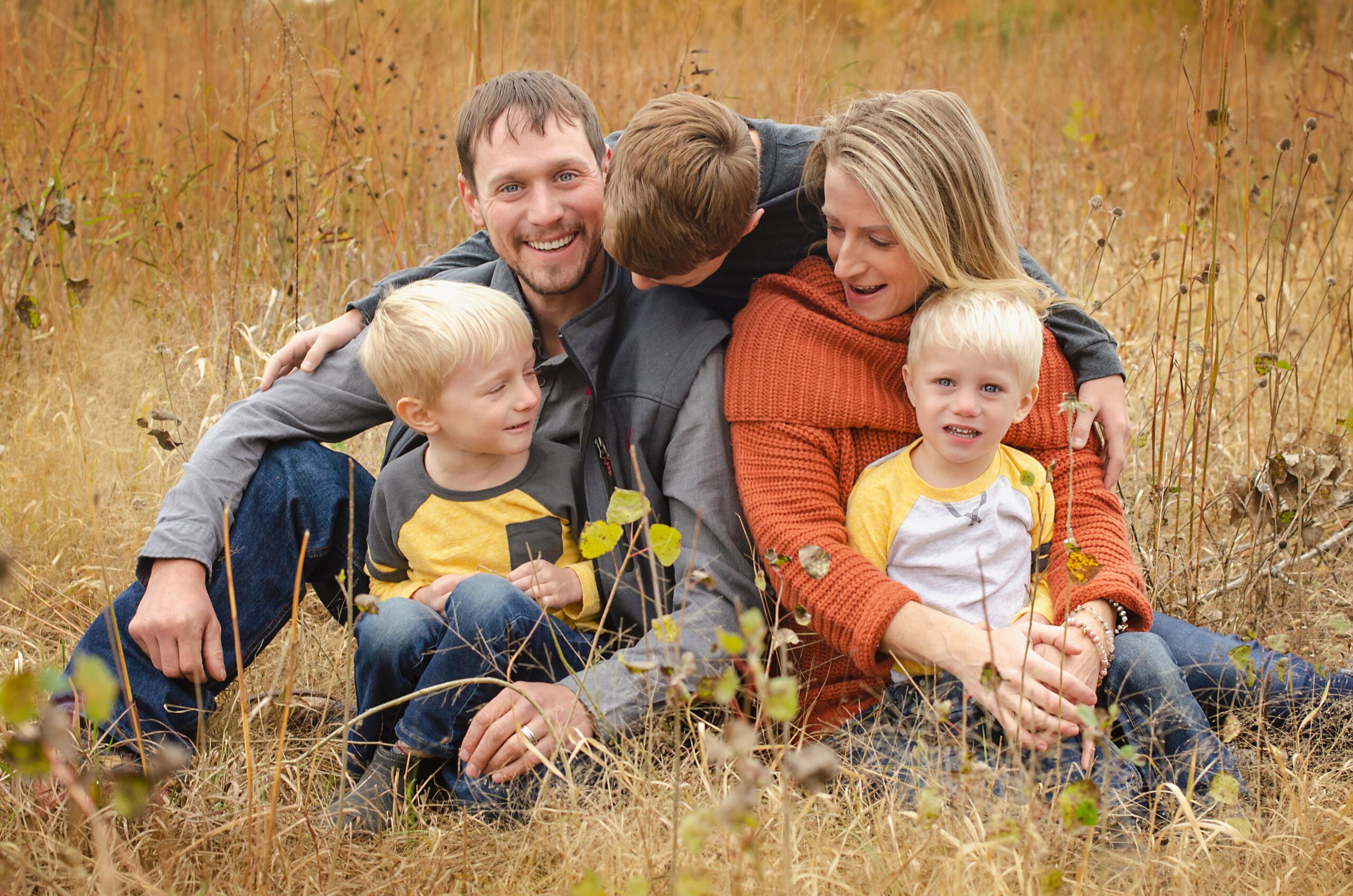A loving family of five enjoying quality time in an autumn field, capturing warmth and togetherness.